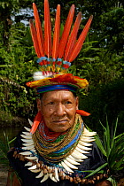 Cofan indian in traditional dress with parrot feathers and peccary teeth, Ecuador