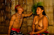 Colorado indian man spraying from mouth a medicinal concoction over a woman to be healed, Santo Domingo de Los Colorados, Ecuador