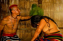 Colorado indian spraying from mouth a curative concoction over a woman to be healed, Santo Domingo de Los Colorados, Ecuador