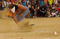 Woman competing in chicken decapitation contest, Puerto Lopez, Ecuador 2004