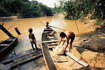 Transporting latex rubber ball by boat to market, Acre, Brazil