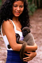 Girl with pet baby Woolly monkey {Lagothrix lagothrix} Amazonas, Brazil. Endangered.