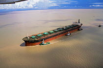 Tugs guide ship carrying iron ore in harbour, Ponta da Madeira, Sao Lius, Maranhao, Brazil.