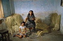 Woman and girl weaving wad palm {Copernicia cerifera} Aracati, Ceara, NE Brazil