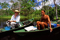 Researcher studying the black river water of Mamiraua Ecol. Stn, Amazonas, Brazil