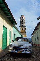 Car, street and bell tower in Trinidad, colonial city of central Cuba