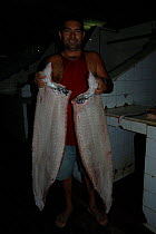 Man with Pirarucu {Arapaima gigas}, Santarem fish market, Brazil.