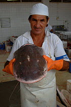 Man with the head of a Piraiba in Santarem fish market, Brazil. {Brachyplatystoma filamentosum).