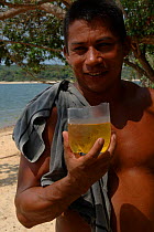 Local man drinking beer from an improvised cup. Para State, Brazil.