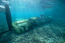 Diver sitting in wreck of WWII Japanese fighter plane, Palau, Micronesia