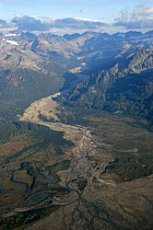 Aerial view of braided river channel and alluvial fan flowing into coastal creek, Alaska.