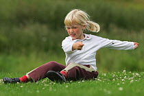 Young girl playing in summer meadow, Cairngorms National Park, Scotland, UK. Model released.