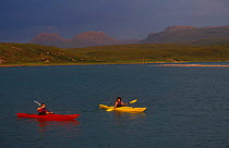 Two sea kayakers in secluded bay, Wester Ross, Scotland, UK.