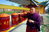Dali Lusing spinning the prayer drums in a Buddhist temple, Kalmykia, Russia.