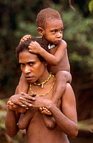 Korowai woman carrying her child on her shoulders, Western Papuasia, Indonesia. 1999 / 2000. (West Papua).