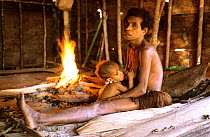 Koroway woman at home nursing her baby, Western Papuasia, Indonesia. (West Papua).