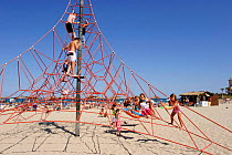 Children playing on climbing frame, Playa de la Zenia, Orihuela, Alicante, Spain.