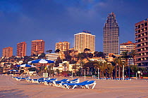 Cala Poniente at sunrise, Benidorm, Spain. High-rise buildings and sun loungers