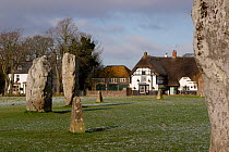 Avebury Stone Circle (World Heritage Site) with pub and other village buildings, Avebury, Wiltshire, UK.