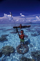 Bajau boy proudly holds speargun with fish, Sabah, Borneo, Malaysia