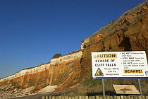 Coastal erosion warning sign at Hunstanton cliffs, Norfolk, UK.