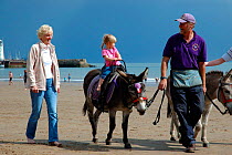 Young girl on donkey ride at seaside, Scarborough, North Yorkshire, UK. 2005