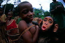 Orphaned pet chimpanzee (Pan troglodytes) with owner, Central Africa. Pet chimpanzees have become a status symbol in some parts of Central Africa.