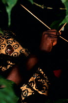 Hunter using bow and arrow, wearing leopard mask, South Kivu, Democratic Republic of Congo. The masks stimulate alarm calls from primates, helping to pinpoint their location so they can be shot with p...