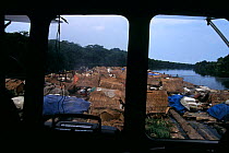 Makeshift huts of travelling bushmeat traders tied to floating timber raft. Bushmeat trade occurs in tandem with the logging industry and is shipped alongside timber on log floats, river ferries, trai...