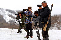 Photographers from around the world photographing Bears at geyser with ranger, Vladimir Zlotnikov, in foreground, Kronotsky Zapovednik Reserve, Russia.