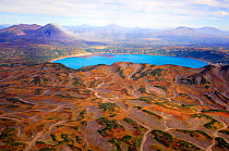 Aerial view of Karymskoye Lake with Karymsky, the most active volcano on Kamchatka, smoking in background, Russia.
