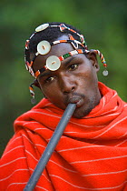 Samburu young man playing a homemade flute. Masai mara, Kenya. 2005.