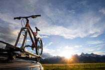 Mountain bike on top of car in bike rack with sunset  Grand Teton NP, Wyoming, USA