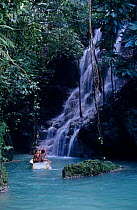 Tourists in boat with tour guide, Somerset Falls, Port Antonio, Jamaica.