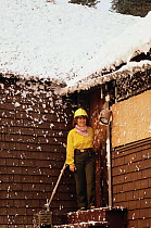Photographer's family in wood cabin sprayed with fire retardant foam to protect it from forest fire, Yellowstone NP, Wyoming, USA. 1988