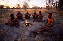 Jo / Hoan bushmen people sitting round fire, Bushmanland, Namibia. 1996
