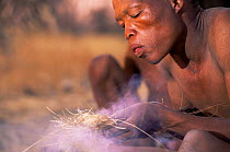 Jo / Hoan bushman making fire by traditional method, Bushmanland, Namibia.