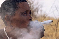 Jo / Hoan bushman smoking traditional pipe, Bushmanland, Namibia. 1996