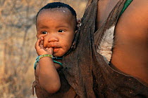 Jo / Hoan bushman baby sucking his thumb, Bushmanland, Namibia. 1996