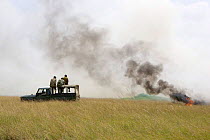 Park rangers set fire to the plains by dragging burning tyre behind truck, Maasai Mara Reserve, Kenya