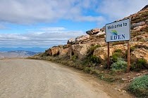"Welcom to Eden" signpost next to road by Swartberg Mountains (Biodiversity Hotspot) Little Karoo, South Africa.