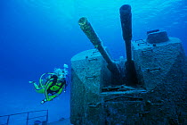 Diver examines cannons on wreck of Russian missile frigate, Destroyer 356, renamed MV Capt Keith Tibbets, Cayman Islands, Caribbean
