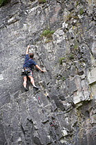 Climber scaling Limestone cliffs of Cheddar Gorge, Cheddar, Somerset, England.