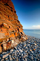 Rock cliff and pebble beach at Sandymouth bay, Cornwall, UK.