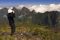 Tourist enjoying the view from Marojejy peak (2140m) High altitude montain forest, Marojejy NP, north east Madagascar.