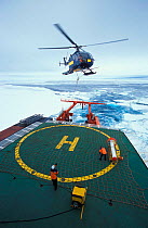 Helicopter taking off with instrument "bird" to measure ice thickness. ISPOL (ICE Station Polarstern) Expedition 2004/2005 from Alfred Wegener Institute, Bremerhaven, Germany. The Icebreaker Polarster...