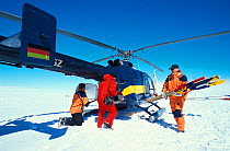 Helicopter crew and researcher loading helicopter on ice floe. ISPOL (ICE Station Polarstern) Expedition 2004/2005 from Alfred Wegener Institute, Bremerhaven, Germany. The Icebreaker Polarstern was dr...