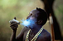 Hadzabe tribesman smoking from traditional pipe, Lake Eyasi Basin, Tanzania 2006