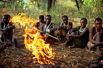 Hadzabe hunter gatherer tribesmen sitting round camp fire for evening storytelling, Lake Eyasi Basin, Tanzania 2006