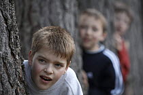 Three boys playing in the forest, Cairngorms National Park, Scotland, UK 2006 Model released.